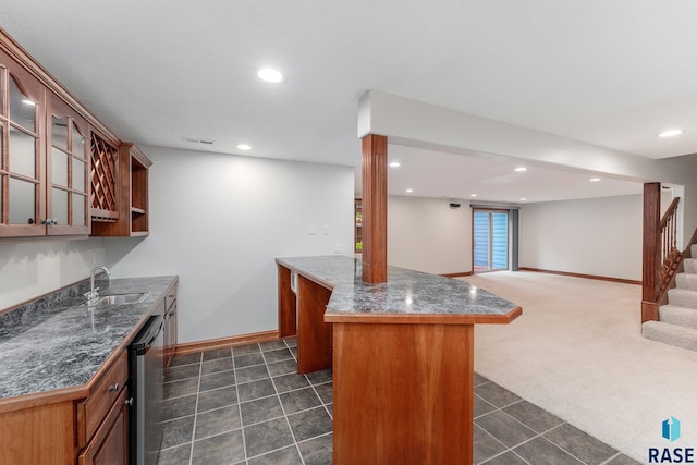 kitchen featuring a kitchen island, sink, a breakfast bar, dark carpet, and stainless steel dishwasher