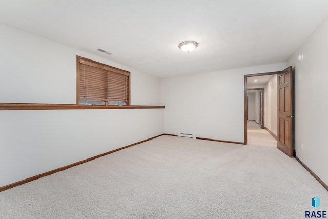 carpeted empty room with a baseboard radiator