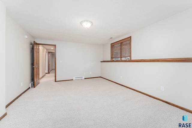 empty room with baseboard heating and light colored carpet