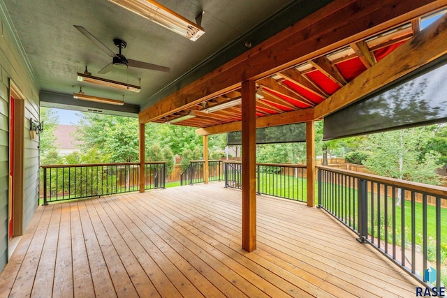 wooden deck featuring ceiling fan and a yard