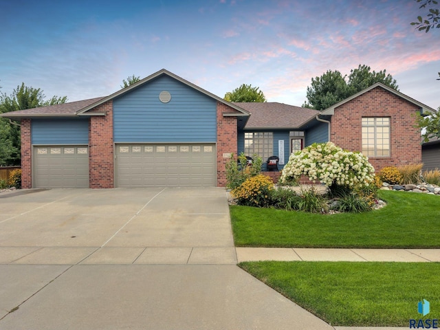 view of front of home featuring a garage and a lawn