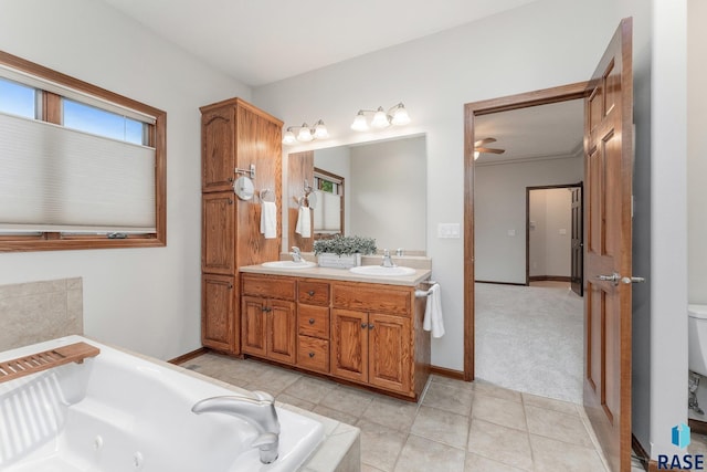 bathroom featuring toilet, tiled bath, tile patterned floors, and vanity