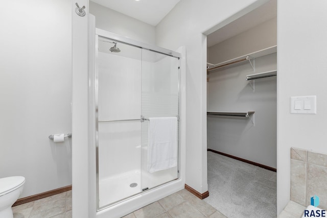 bathroom with tile patterned floors, an enclosed shower, and toilet