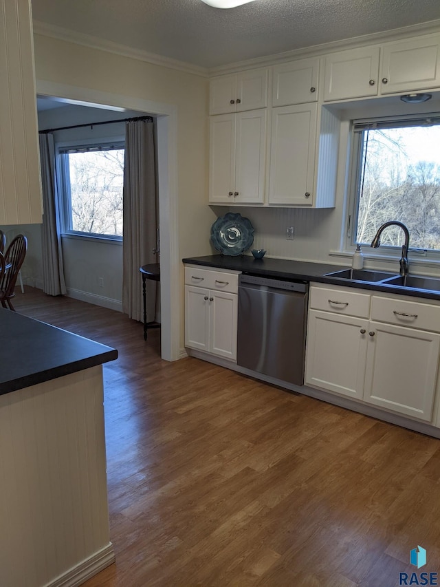 kitchen with light wood-type flooring, dishwasher, sink, and white cabinetry