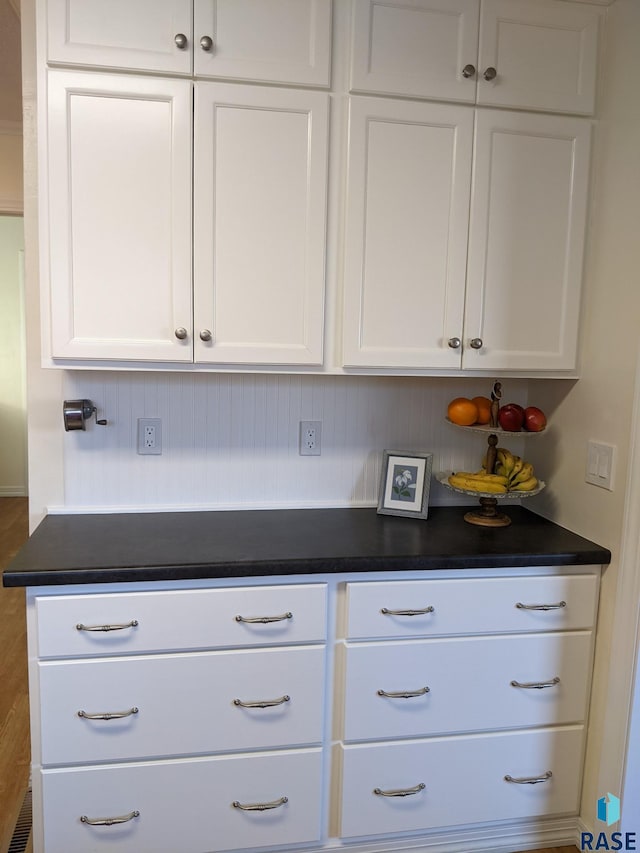 interior space featuring backsplash and white cabinets