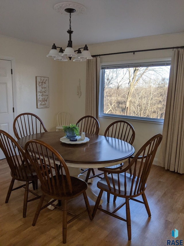 dining area with light wood-type flooring and a chandelier