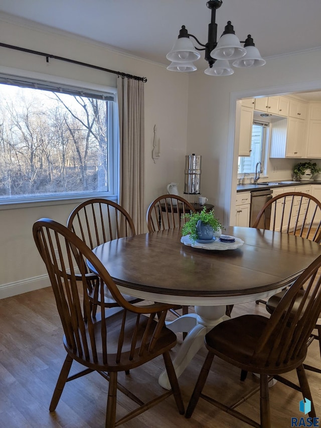 dining room with light wood-type flooring, an inviting chandelier, and crown molding