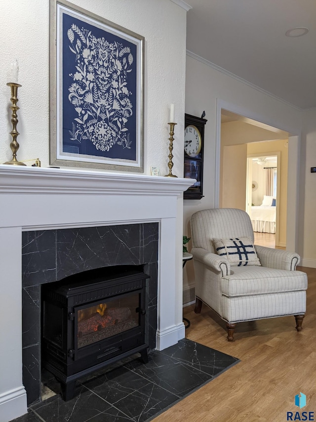 sitting room with a high end fireplace, dark hardwood / wood-style flooring, and ornamental molding