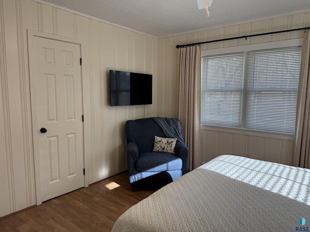 bedroom with a textured ceiling and hardwood / wood-style flooring