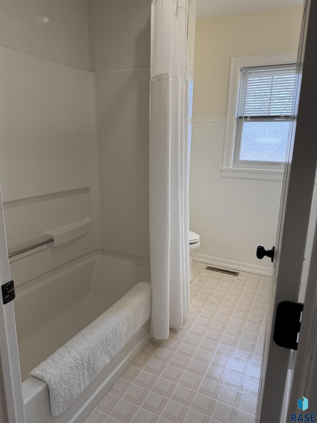 bathroom with toilet and shower / bathtub combination with curtain