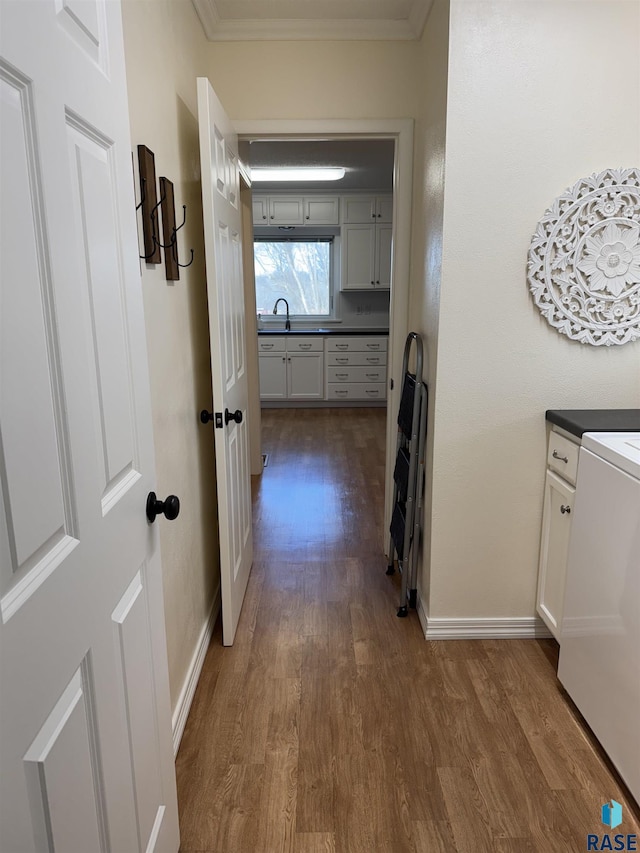 hall with crown molding, dark hardwood / wood-style floors, and washer / dryer