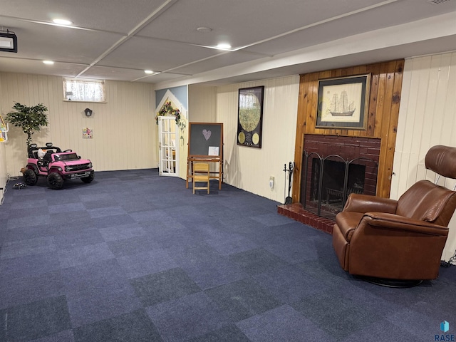 living area featuring a fireplace and wooden walls