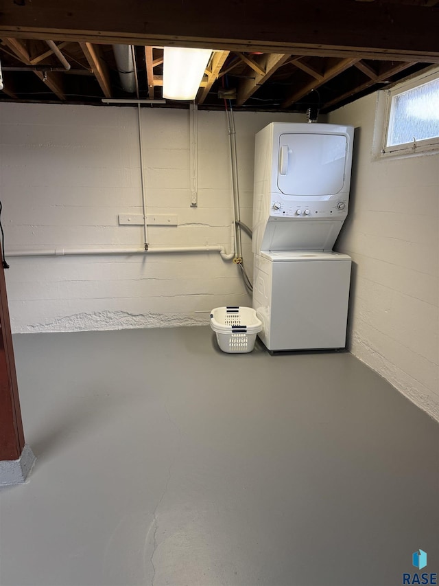 basement with stacked washing maching and dryer