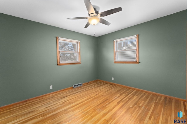 empty room featuring ceiling fan, light hardwood / wood-style flooring, and plenty of natural light