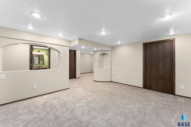 basement featuring light colored carpet