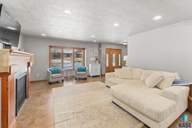 living room with a textured ceiling, light tile patterned floors, and a tile fireplace