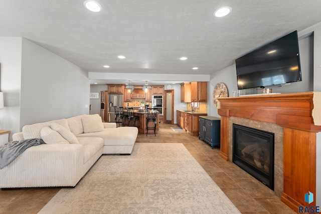 living room featuring sink and a tiled fireplace