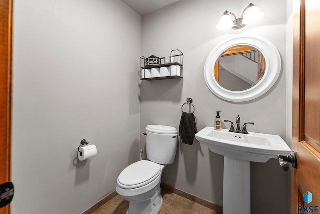 bathroom featuring sink, toilet, and tile patterned flooring