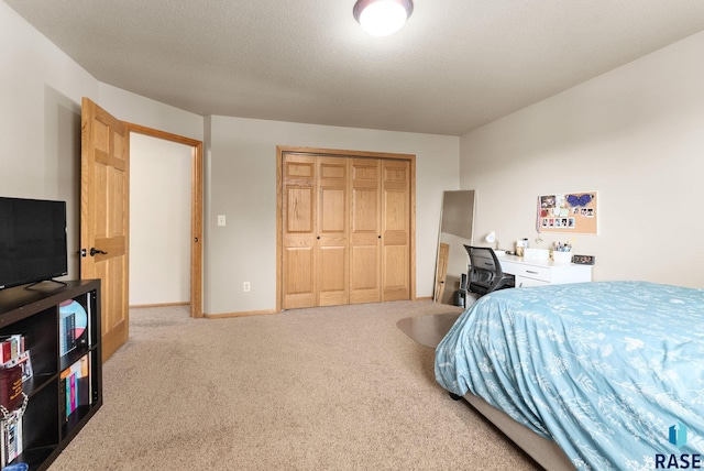 bedroom with a textured ceiling, carpet flooring, and a closet