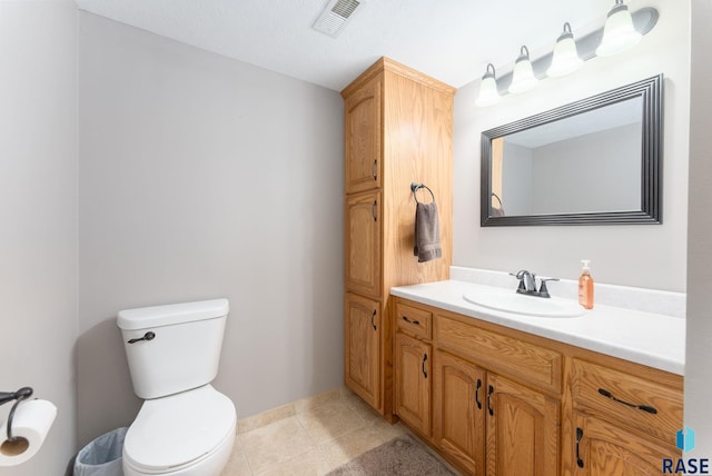 bathroom with vanity, toilet, and tile patterned floors