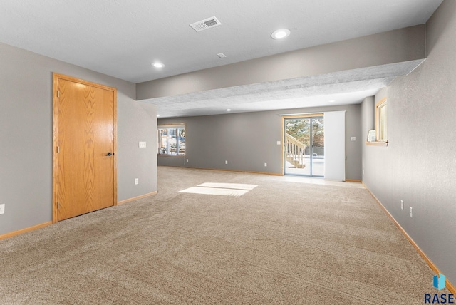 carpeted empty room with a textured ceiling