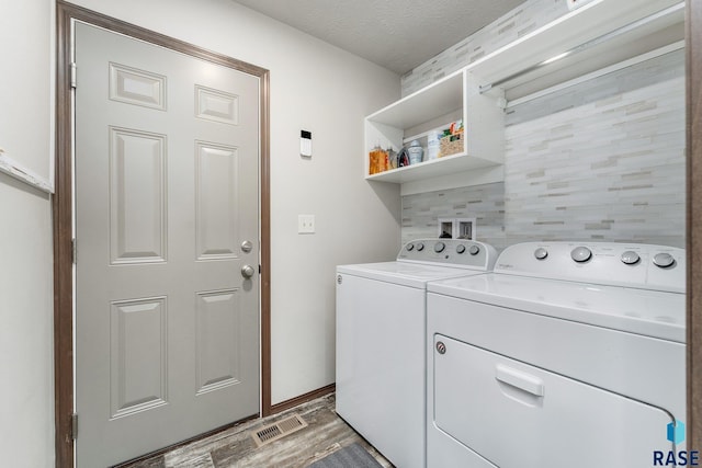 laundry area featuring washing machine and dryer, dark wood-type flooring, and a textured ceiling