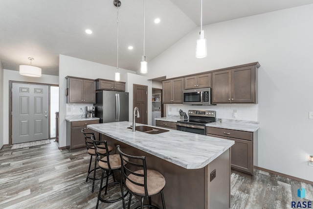 kitchen featuring hanging light fixtures, backsplash, and stainless steel appliances