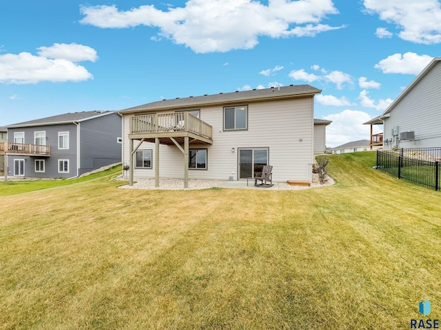 rear view of house with a deck, a lawn, and a patio