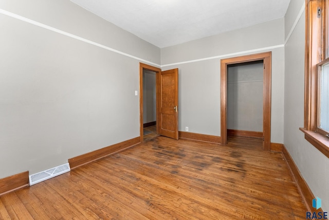 unfurnished bedroom with a closet and hardwood / wood-style flooring