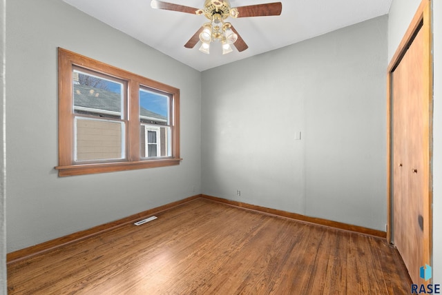 unfurnished bedroom with ceiling fan, a closet, and hardwood / wood-style floors