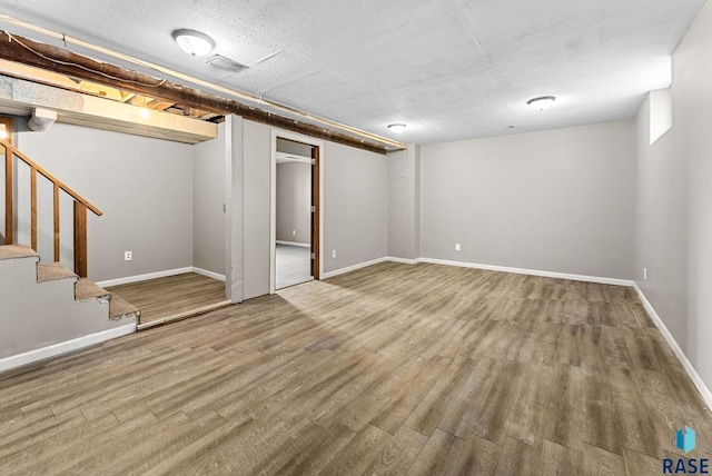 basement with a textured ceiling and hardwood / wood-style flooring