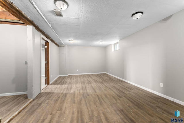 basement with a textured ceiling and hardwood / wood-style floors