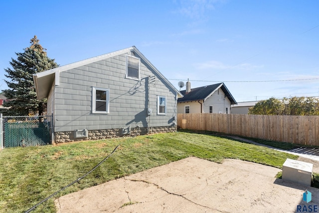 back of house with a yard and a patio