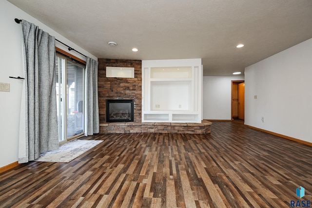 unfurnished living room featuring a textured ceiling, dark wood-type flooring, and a fireplace