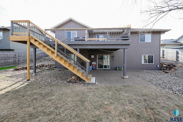 back of house featuring stairs, a deck, a patio area, and fence