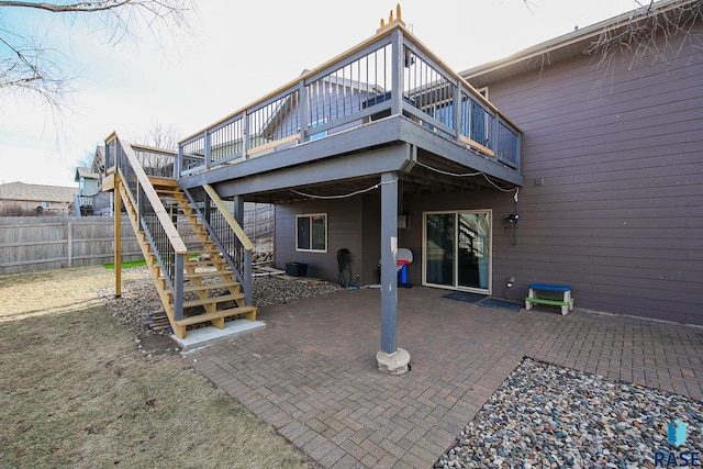 back of property featuring stairway, fence, a deck, and a patio