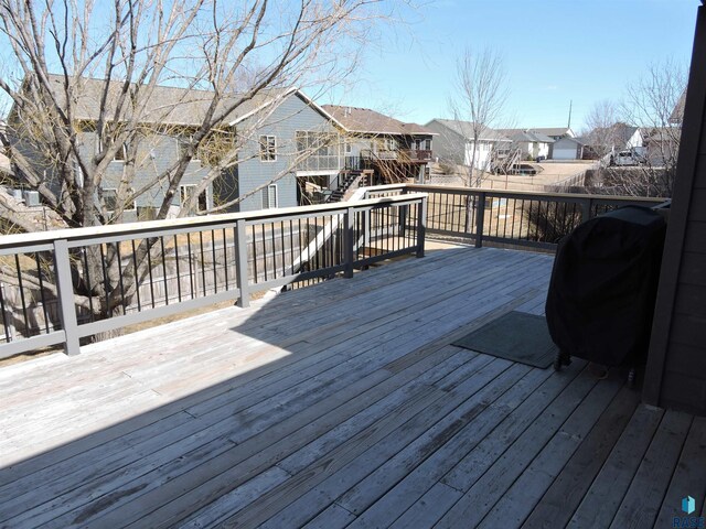 wooden deck with area for grilling and a residential view