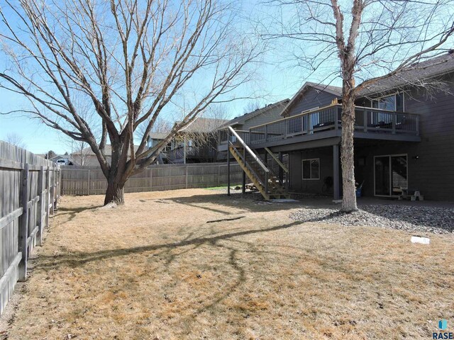 view of yard with stairs, a fenced backyard, and a wooden deck