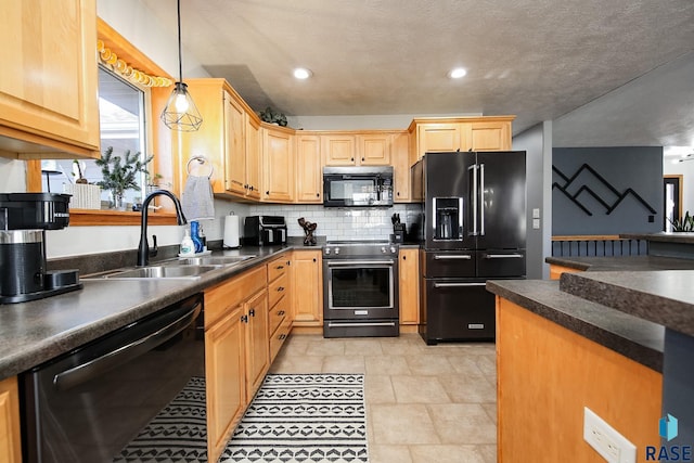 kitchen with dark countertops, black appliances, backsplash, and a sink