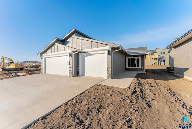 view of front of property featuring a garage and central air condition unit