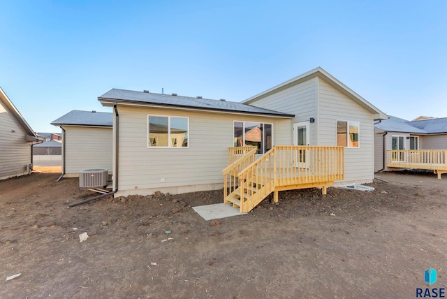 rear view of property with cooling unit and a deck