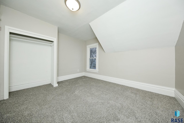 additional living space featuring vaulted ceiling and carpet