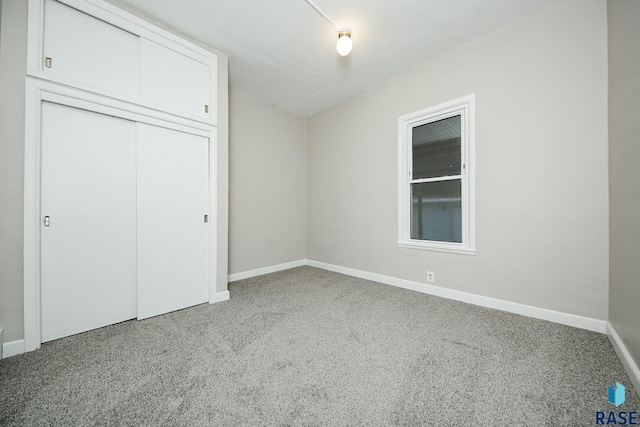 unfurnished bedroom featuring light carpet and a closet