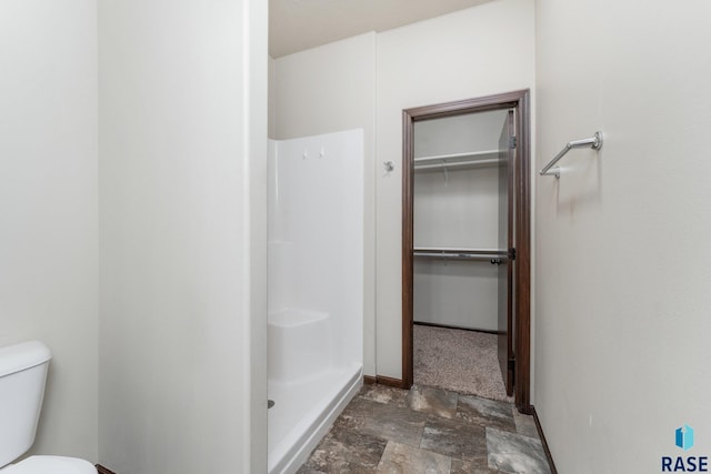 bathroom with toilet and a shower