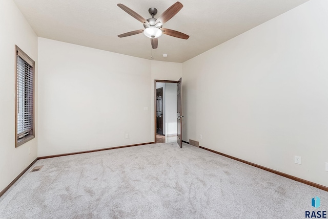 spare room with light colored carpet and ceiling fan