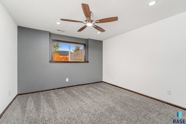 carpeted spare room featuring ceiling fan