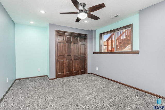 unfurnished bedroom featuring a closet, ceiling fan, and carpet flooring