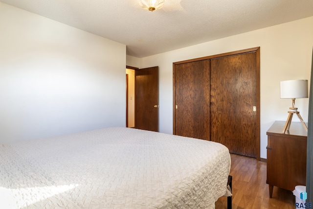 bedroom featuring hardwood / wood-style floors, a closet, and a textured ceiling