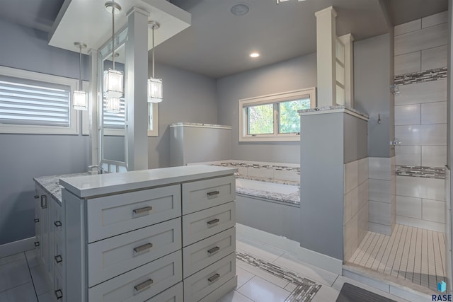 bathroom featuring a tile shower, tile patterned floors, and vanity