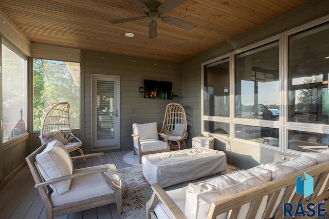 sunroom / solarium featuring ceiling fan, plenty of natural light, and wooden ceiling